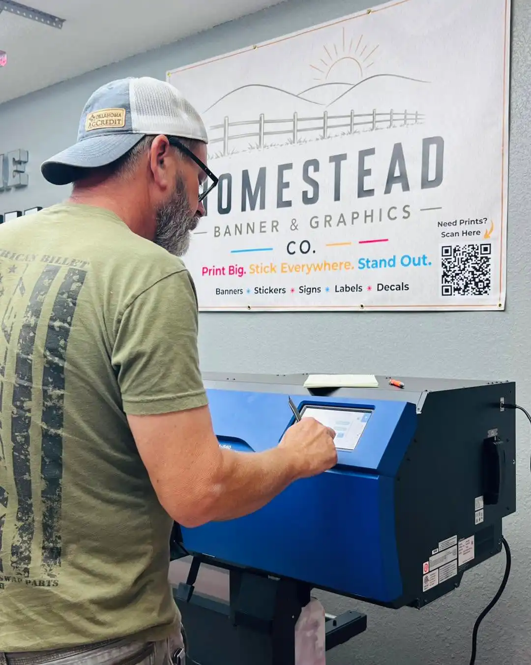 Team member operating a large-format printer in the Homestead shop
